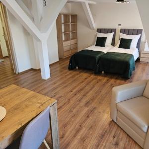 una camera da letto con due letti e un tavolo di Apartamenty Tadeusza Kościuszki 4 Szmaragdowy a Działdowo