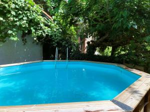 a swimming pool with a wooden deck around it at Gite Esmeralda in Biert