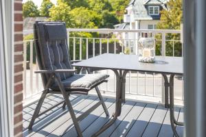 a chair and a table on a balcony at Villa Dornkamp 5 - Luxuriöse Ferienwohnung für 2 Personen inklusive Sauna und Balkon in Timmendorfer Strand