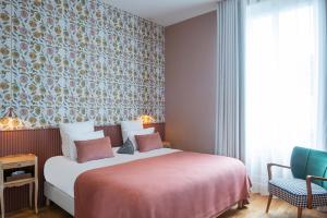 a bedroom with a bed and a floral wall at Hôtel Maison Lacassagne Lyon in Lyon