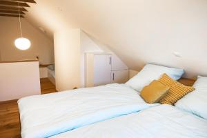 - une chambre avec un lit blanc et des oreillers dans l'établissement Ferienwohnung in der alten Scheune Wiesenblick für 3 Personen, à Ohne