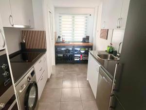 una pequeña cocina con fregadero y lavavajillas en Lovely New Luxery Beach Apartment in Mojacar Playa next to the best beach, en Mojácar