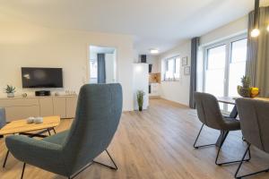 a living room with a table and chairs and a television at Dorumer Sielhuus 4 - Ferienwohnung mit Garten und Sauna in Dorum