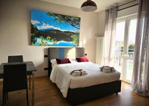 a bedroom with a bed and a desk and a painting at 7 LAKES Aparthotel in Burolo