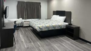 a bedroom with a bed and a dresser and a desk at Studio 6 Oklahoma City, OK South in Oklahoma City