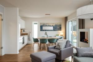 a kitchen and living room with a table and chairs at Ferienhaus Sonnenweg 32 - Sauna, Garten und Seeblick inklusive in Diemelsee +24 photos