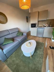 una sala de estar con un sofá y una mesa en Les Quais centre-ville, en Rennes