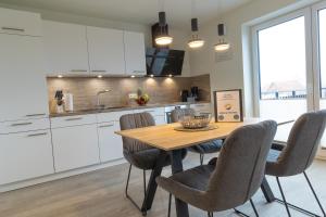 a kitchen with a wooden table and chairs at Dorumer Sielhuus 13 mit Sauna und Balkon in Dorum +13 photos