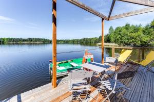 a dock with chairs and a boat on the water at Domaine des Etangs de Taysse in Espagnac