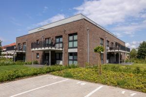 a brick building with a parking lot in front of it at Dorumer Sielhuus 7 - Ferienwohnung mit Terrasse und Sauna in Dorum