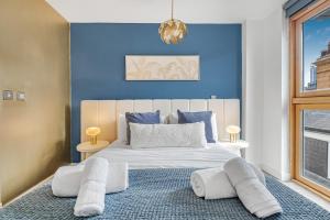 a bedroom with a large white bed with blue walls at Golden View-Wyndale Living-Central Birmingham in Birmingham