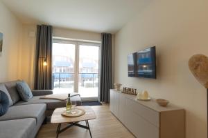 TV a/nebo společenská místnost v ubytování Ferienwohnung Hyggelig - Strandnah mit Sauna und Balkon