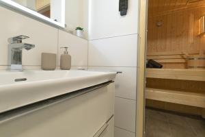 ein Badezimmer mit Waschbecken und Badewanne in der Unterkunft Wolke 7 mit Sauna und Balkon - Hunde willkommen in Kellenhusen + 17 Fotos