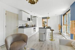 a kitchen and living room with a couch and a chair at Golden View-Wyndale Living-Central Birmingham in Birmingham