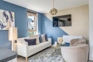 a living room with a white couch and blue walls at Golden View-Wyndale Living-Central Birmingham in Birmingham