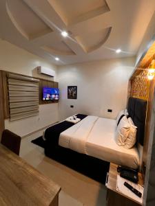 سرير أو أسرّة في غرفة في Triple J Universal Hotel and Suites