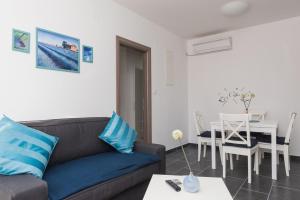 a living room with a couch and a table at M.G Apartments in Brodarica