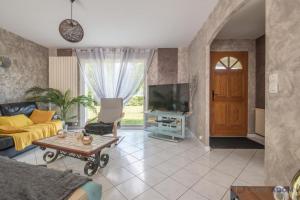 a living room with a couch and a television at La Lilla - Wifi - Piscine - Parking in Chauvé