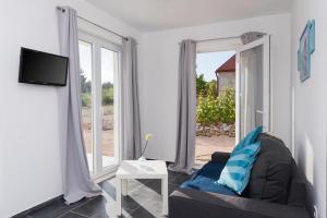 a living room with a couch and a tv at M.G Apartments in Brodarica