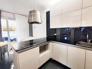 a kitchen with white cabinets and a sink at Mamma Casa Superior Vaniglia in Rimini