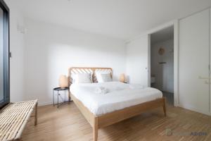 a bedroom with a large bed with white sheets at Sekoya Lodge - Proche plage - golf in Pornic