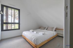 a bedroom with a bed with towels on it at Sekoya Lodge - Proche plage - golf in Pornic