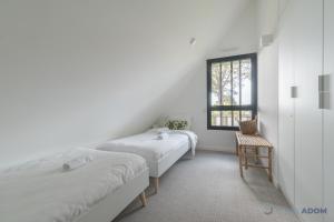 a bedroom with two beds and a window at Sekoya Lodge - Proche plage - golf in Pornic