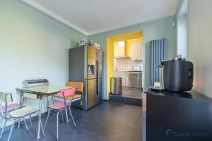 eine Küche mit einem Tisch und rosa Stühlen in einem Zimmer in der Unterkunft L'Oasis - Proche plage - Wifi - Jardin in Pornic