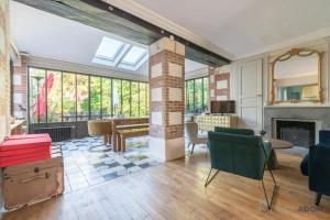 ein Wohnzimmer mit Kamin, Tisch und Stühlen in der Unterkunft L'Oasis - Proche plage - Wifi - Jardin in Pornic