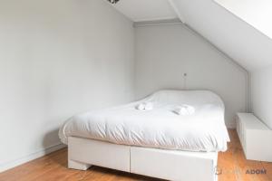 ein Schlafzimmer mit einem weißen Bett und zwei weißen Handtüchern in der Unterkunft L'Oasis - Proche plage - Wifi - Jardin in Pornic