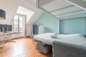 ein Schlafzimmer mit einem Bett und einem Schreibtisch in der Unterkunft L'Oasis - Proche plage - Wifi - Jardin in Pornic + 11 Fotos