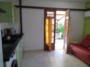 Una cocina con una puerta que da a un patio. en Chez KEKE, en Sainte-Anne