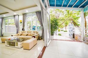 a living room with a couch and a table at Ngoc Trai 01 Villa FLC Sam Son in Sầm Sơn