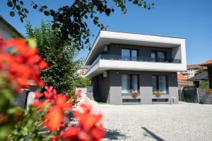 a white house with flowers in front of it at Novum Stay - Pensiune Centrala in Hunedoara in Hunedoara