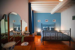 a bedroom with a bed with blue walls and mirrors at Ambiance Morvan in Ouroux