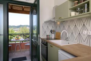 a kitchen with a view of a balcony with a table at Kanali Hill Studio in Kanálion