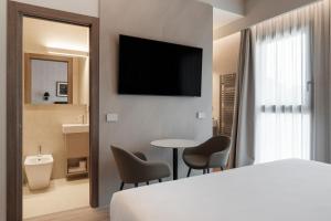a hotel room with a bed and a table and chairs at Lago Dorato Marina Lodge - Lakefront in Colico