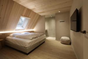 a bedroom with a bed with a window and a television at Lodge met Jacuzzi - 6 personen - Woodz Lodges in Heusden - Zolder