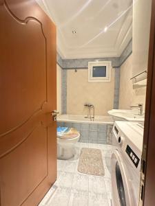 a bathroom with a toilet and a sink and a washing machine at Family Beach apartment in Perea +7 photos