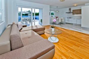 una sala de estar con un sofá y una mesa en Island Hvar Villa LeChalet with Pool, en Bogomolje