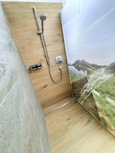 una doccia in un bagno con uno specchio sul pavimento di Stockingbauer a Leogang