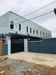 イバダンにあるAM Apartmentsの青いフェンスとガレージのある建物