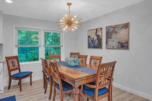 a dining room with a wooden table and chairs at Southern Storm - Modern Stay with Patio & Yard home in Wilmington