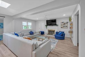 a living room with two white couches and a fireplace at Southern Storm - Modern Stay with Patio & Yard home in Wilmington