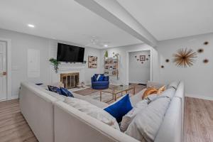a white living room with a couch and a tv at Southern Storm - Modern Stay with Patio & Yard home in Wilmington +28 photos