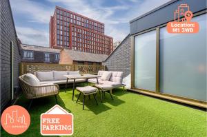 a balcony with green grass and a table and chairs at Stunning Luxury Townhouse in Centre of Manchester in Manchester