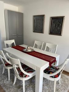 a white dining room with a white table and chairs at Vila Botanic Residence in Sarajevo