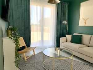 a living room with a couch and a glass table at Maison Emeraude - Escapade bistrot chic & nature - Proche Vannes in Sérent