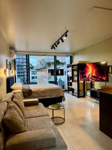 a living room with a couch and a bed and a tv at Foster Studio - Park in Buenos Aires
