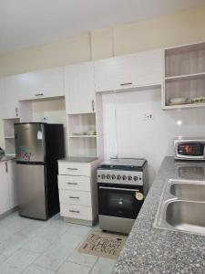 a kitchen with a black refrigerator and a stove at kingdom corner suites in Nairobi